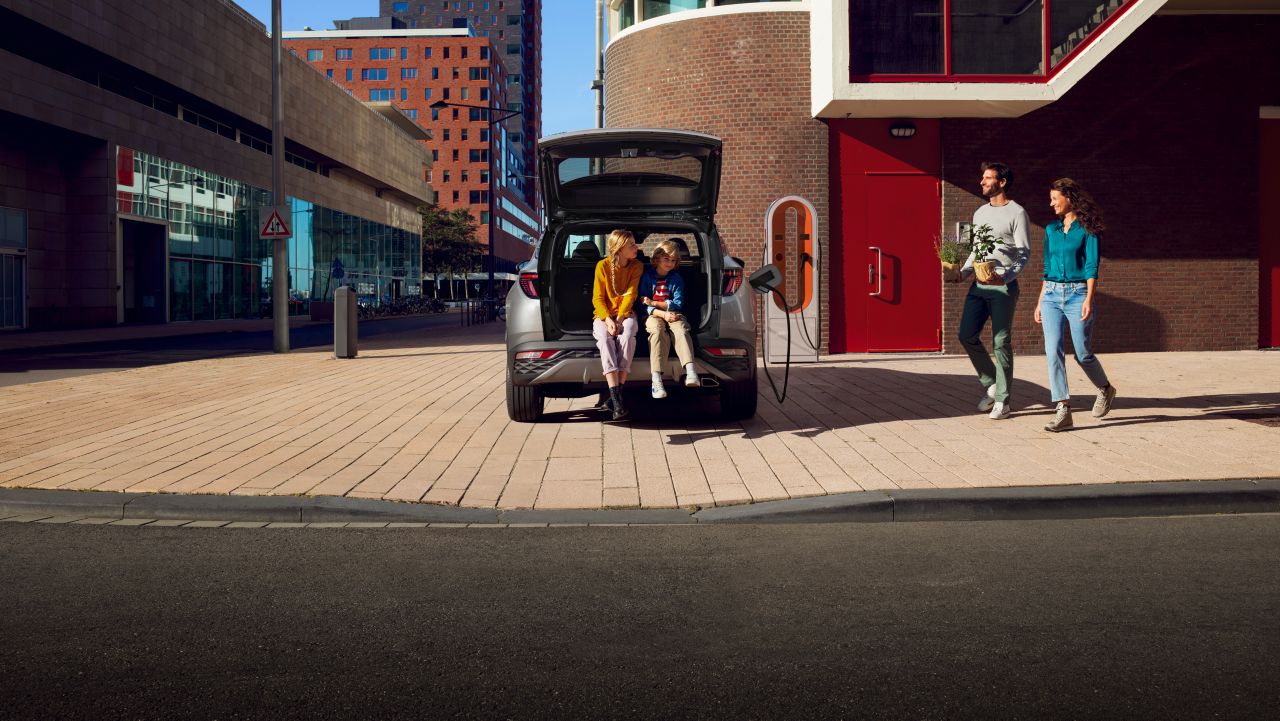 Zcela nové kompaktní SUV Hyundai TUCSON Plug-in Hybrid, zaparkované na chodníku.